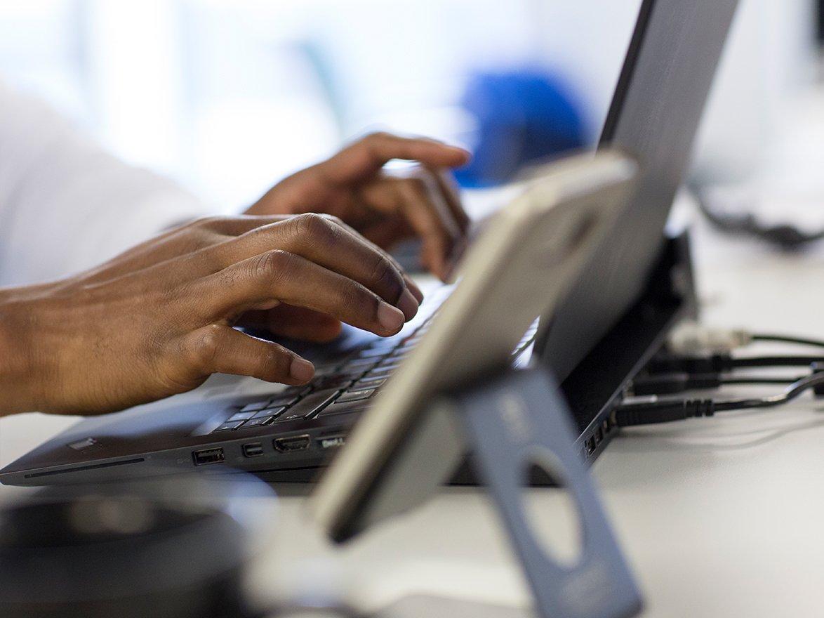 Two hands typing on keyboard